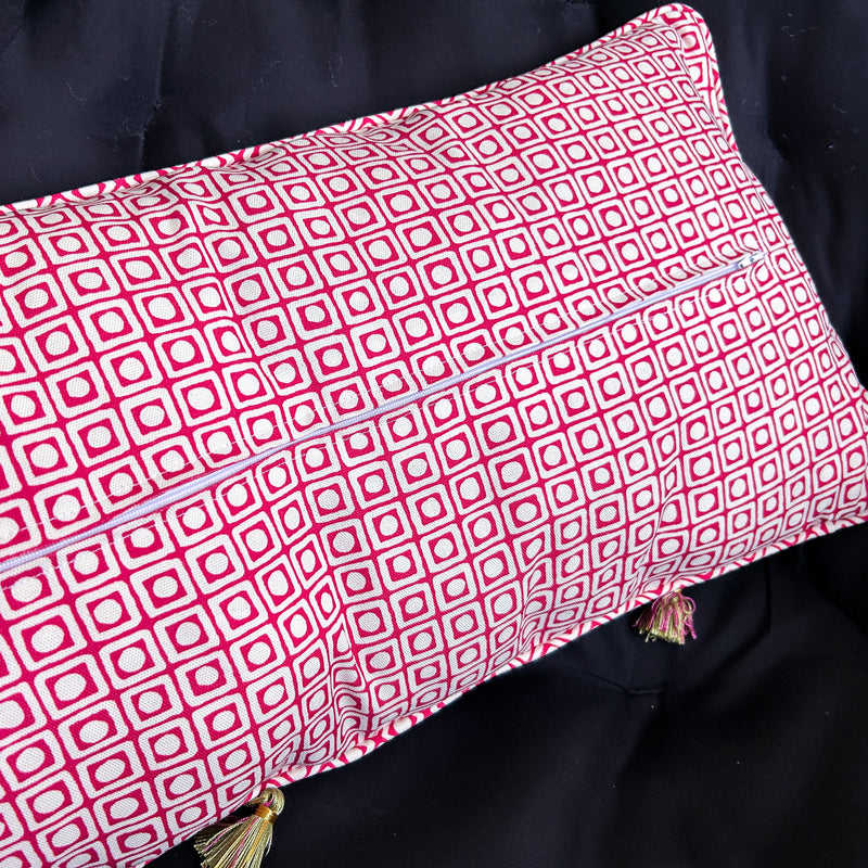 Red and white patterned pillow on a dark background