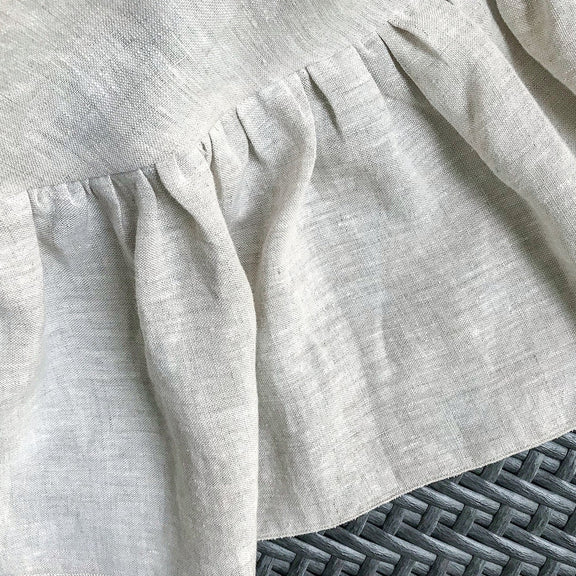 Close-up of a light gray textured fabric with a subtle pattern on a textured surface.