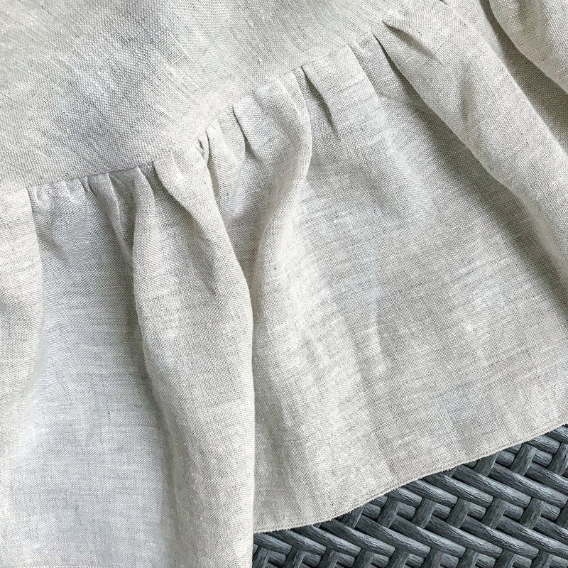 Close-up of a light gray textured fabric with a subtle pattern on a textured surface.
