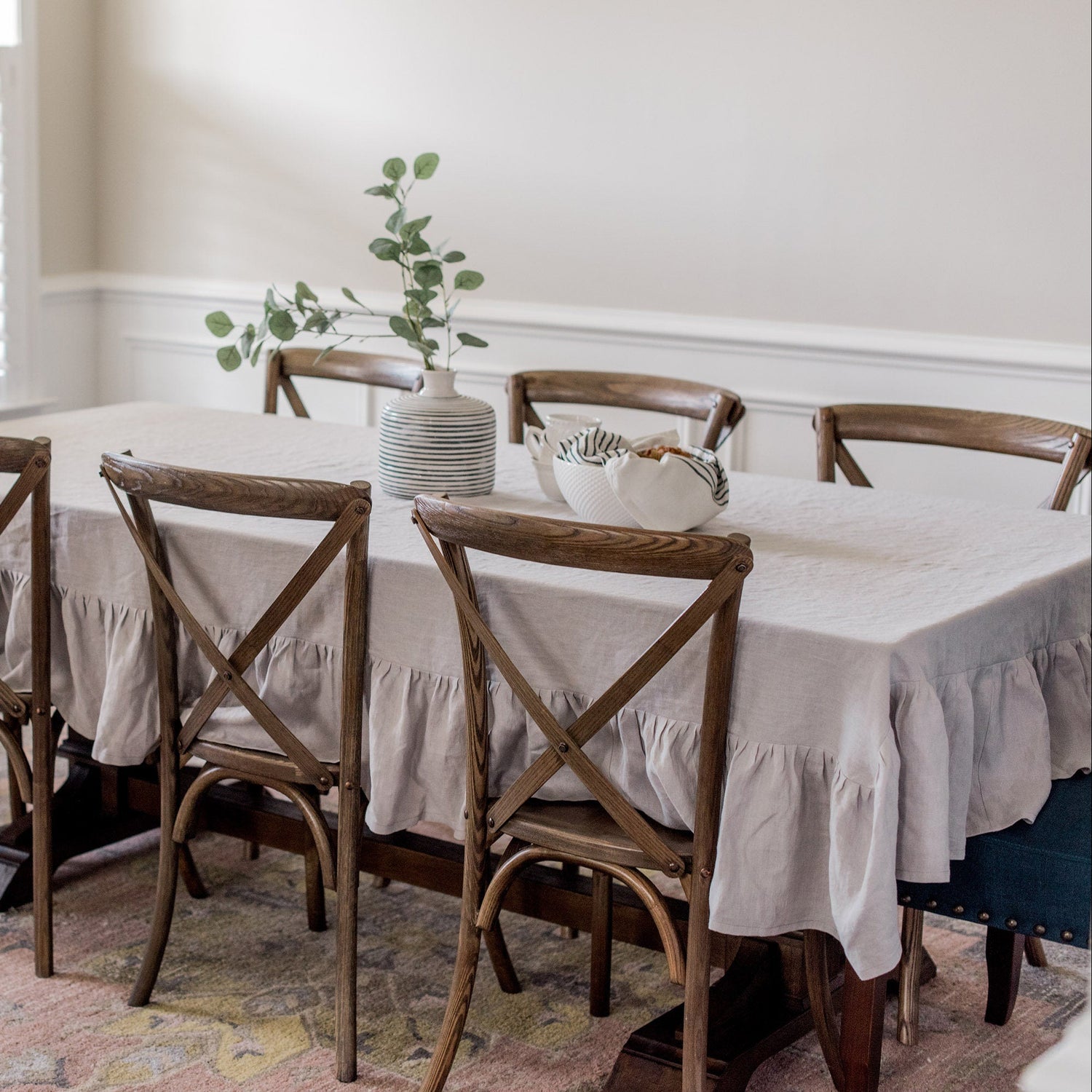 Dining room with a table and chairs set against a neutral wall.