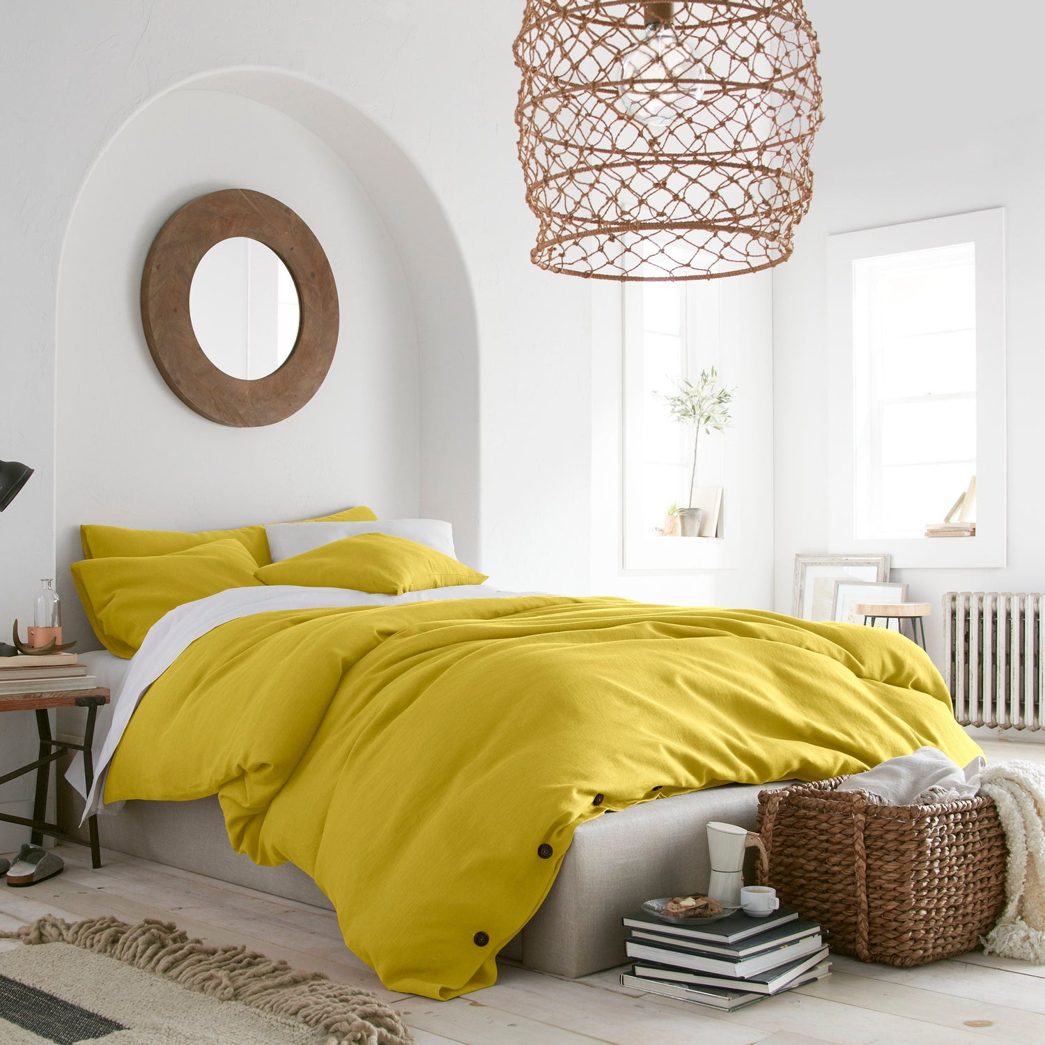 Bedroom with yellow bedding and a wicker lampshade.