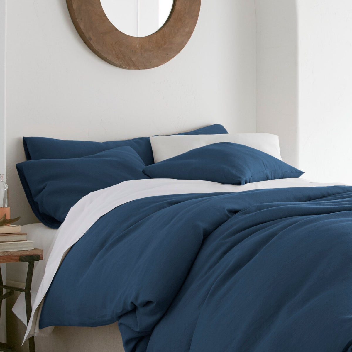 Bed with blue bedding and white pillows in a bedroom setting.