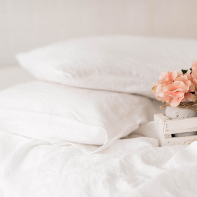 White bedding with pink flowers on a wooden crate