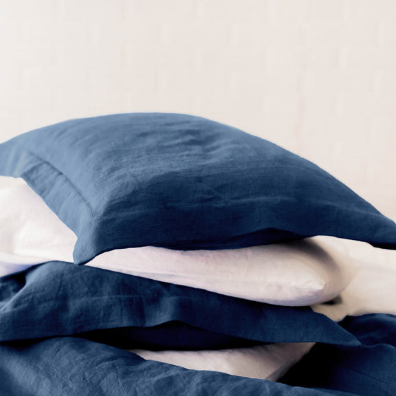 Blue linen duvet and pillows on a bed with a blurred background