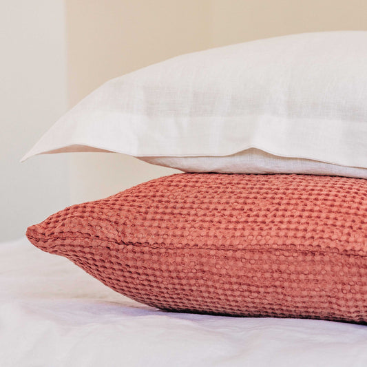 Close-up of a textured pink pillow on a neutral background