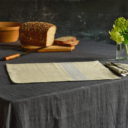 Loaf of bread on a cutting board with a napkin on a table