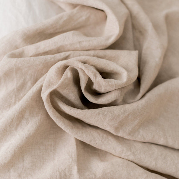 Close-up of beige fabric with folds on a light background