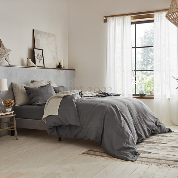 Bedroom with gray bedding and a large window