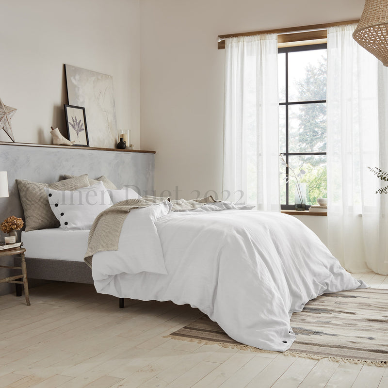 Neatly made bed in a bedroom with light decor
