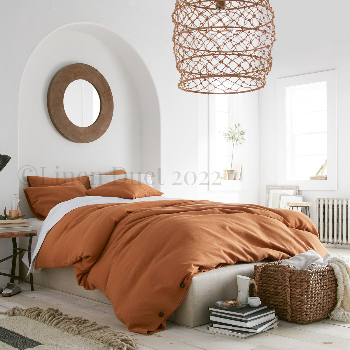 Cozy bedroom with brown bedding and a woven pendant light.