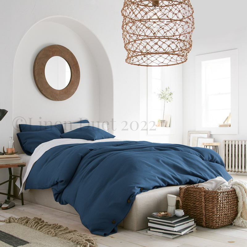 Bedroom with blue bedding, wooden basket, and decorative items.
