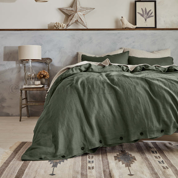 Green bedding set on a bed in a bedroom with decorative elements.