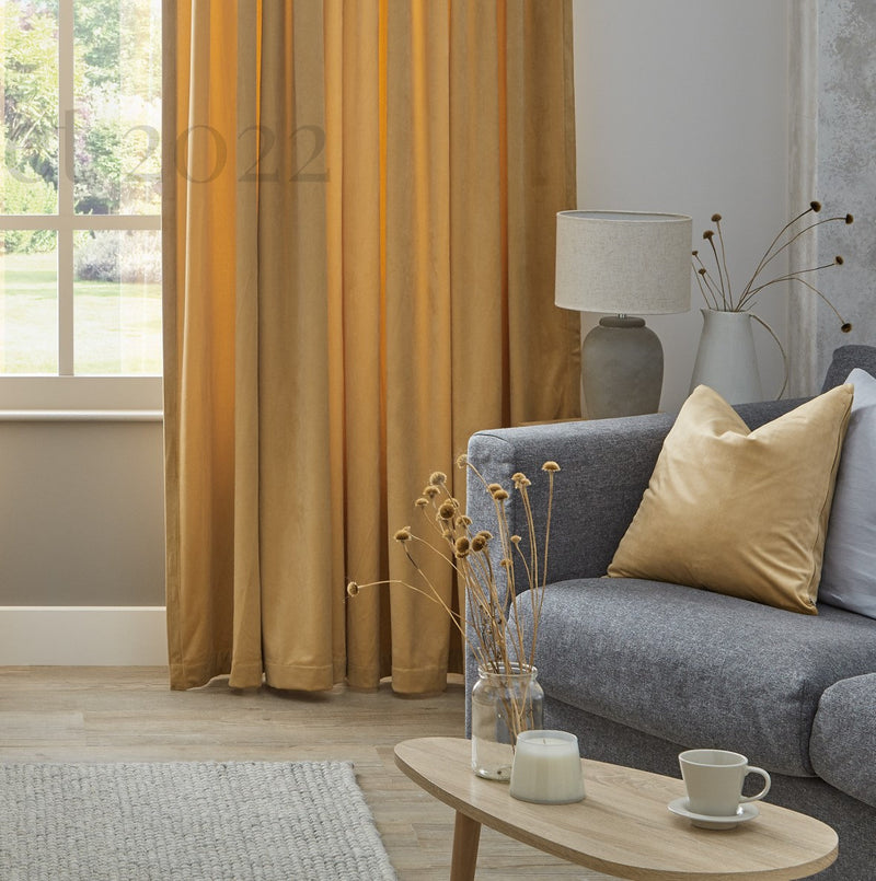 Living room with gray sofa, yellow curtains, and a small table with decor items.
