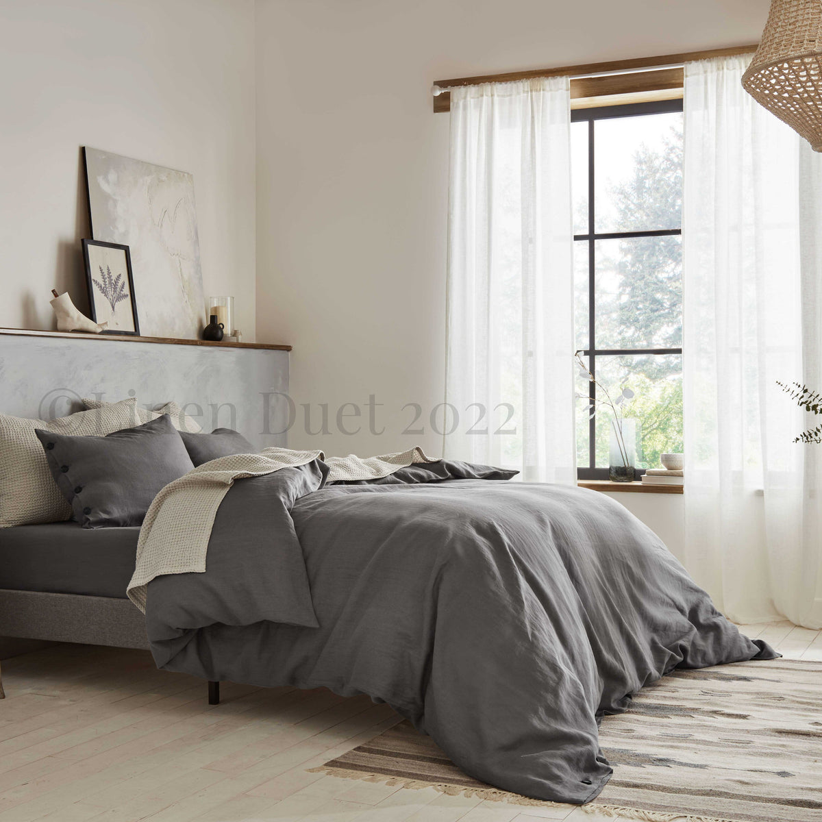 Bedroom with gray bedding and a large window