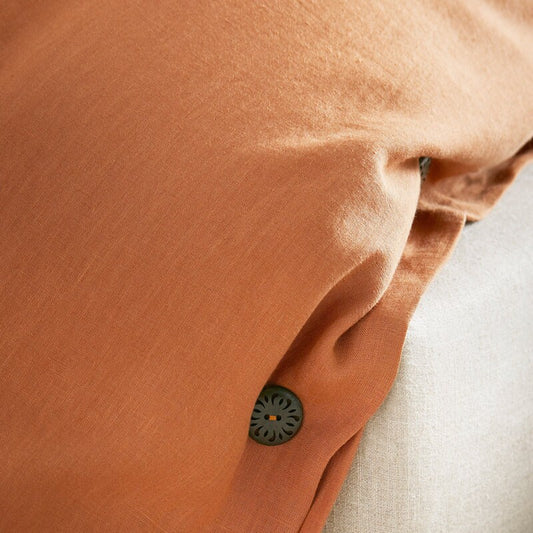 Close-up of a brown fabric with a button, possibly from a garment.