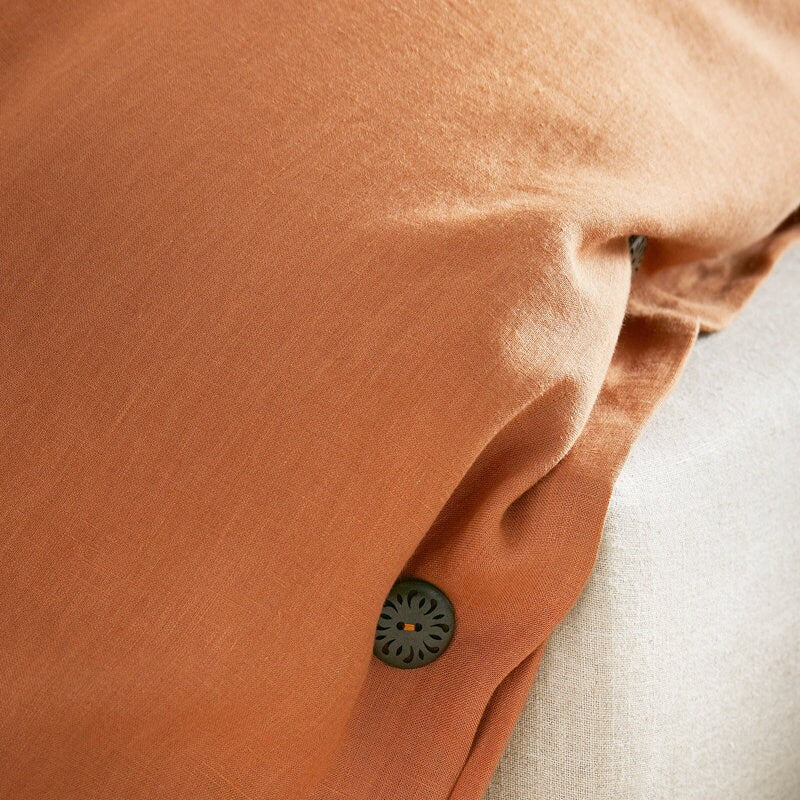 Close-up of a brown fabric with a button, possibly from a garment.