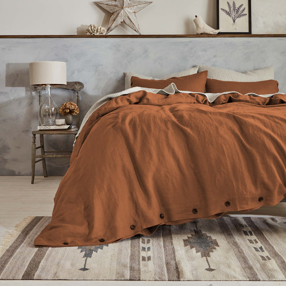 Brown linen duvet on a bed in a bedroom with shelves and decor.