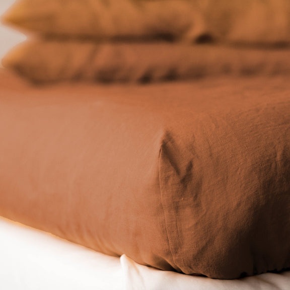 Brown linen duvet on a bed with a blurred background