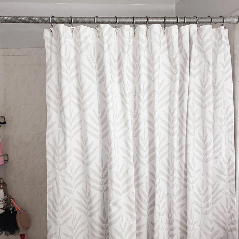 White shower curtain with a subtle pattern in a bathroom setting