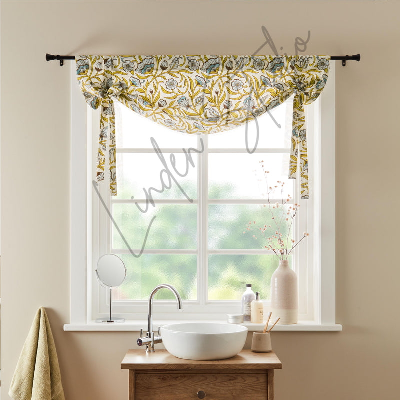 Window with floral valance, sink, and decor in a bathroom setting