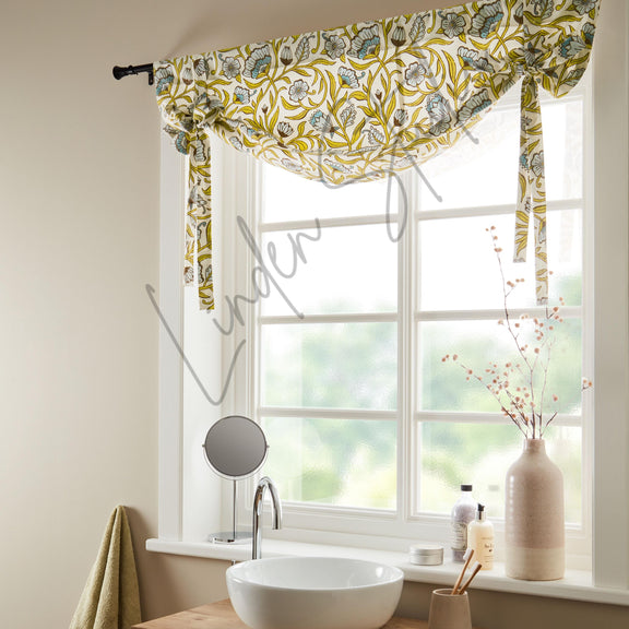 Window with floral curtain, sink, and decorative items in a bathroom setting