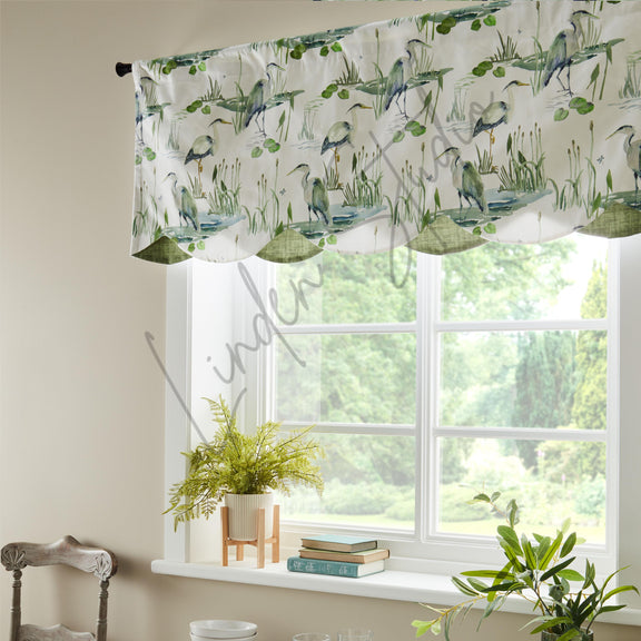 Window with decorative curtain featuring bird and nature pattern, plants on windowsill.