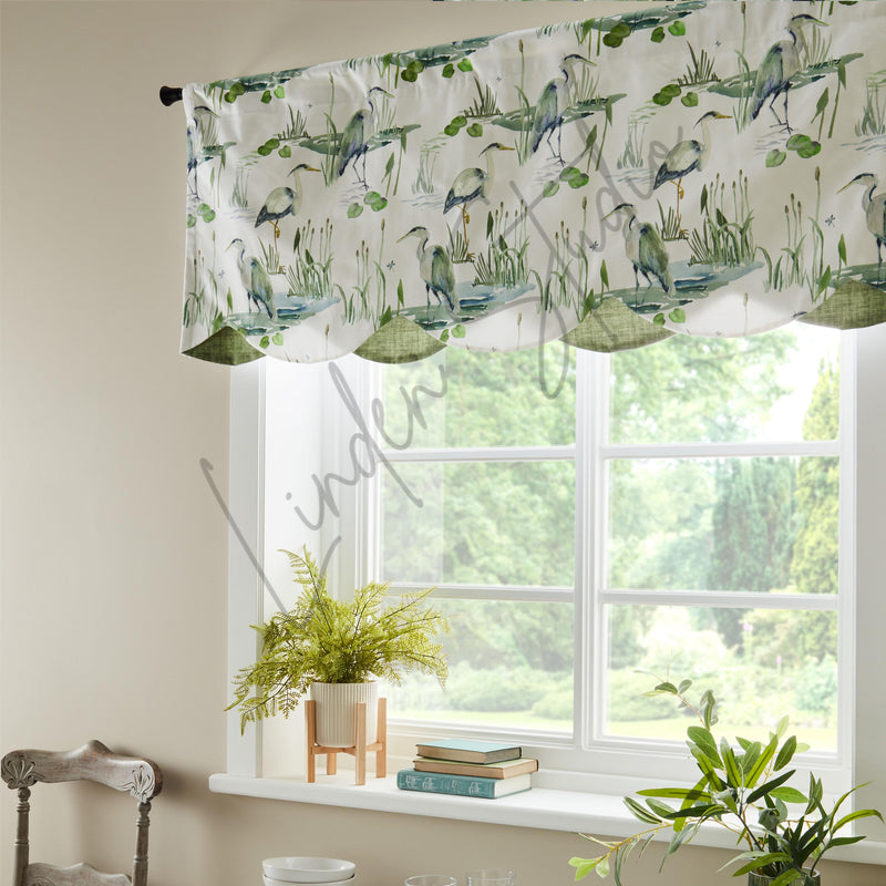 Window with decorative curtain featuring bird and nature pattern, plants on windowsill.