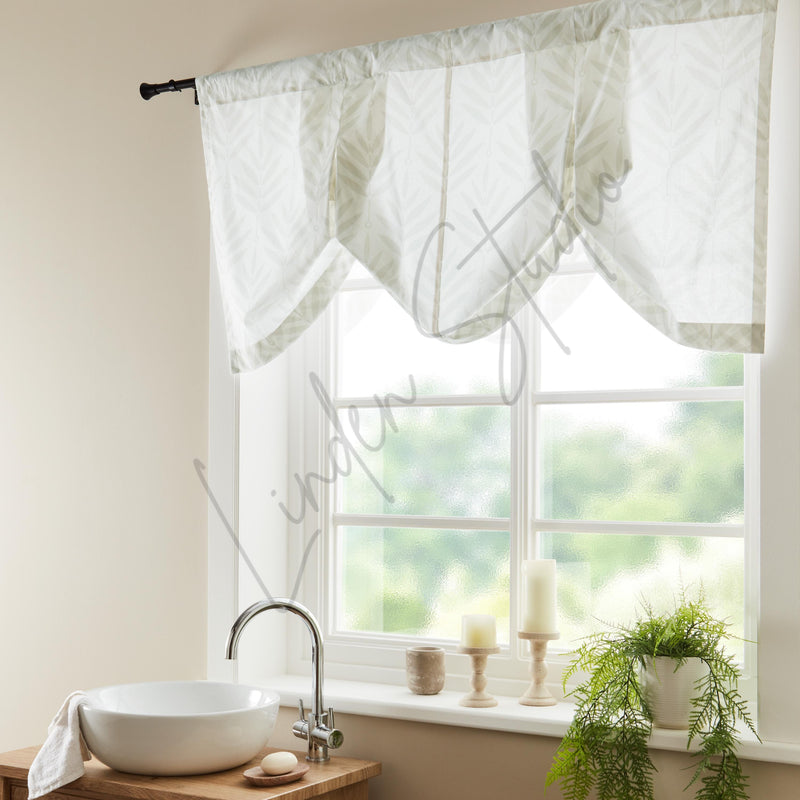 Window with white curtains, sink, and plants in a bright room