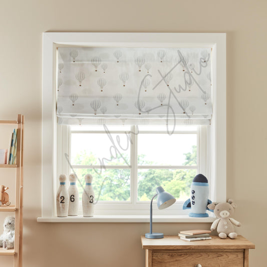 Window with a patterned white blind, desk with books and toys, and decorative items.