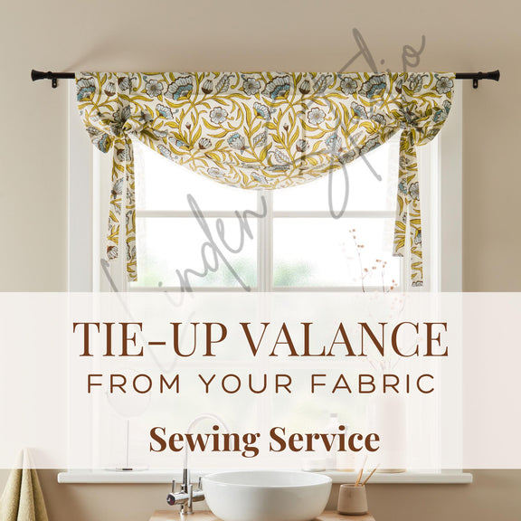 Decorative tie-up valance on a window with text about sewing service.