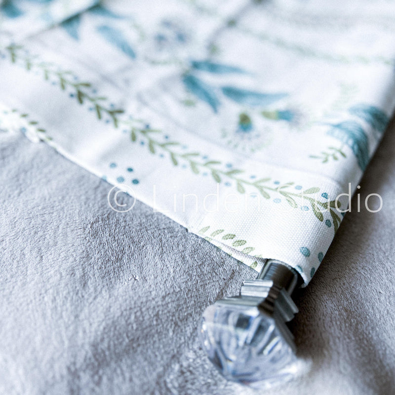 Fabric with floral pattern and decorative clip on a textured surface