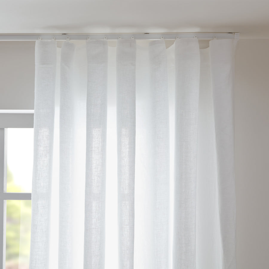 White semi-sheer linen curtains filtering natural daylight
